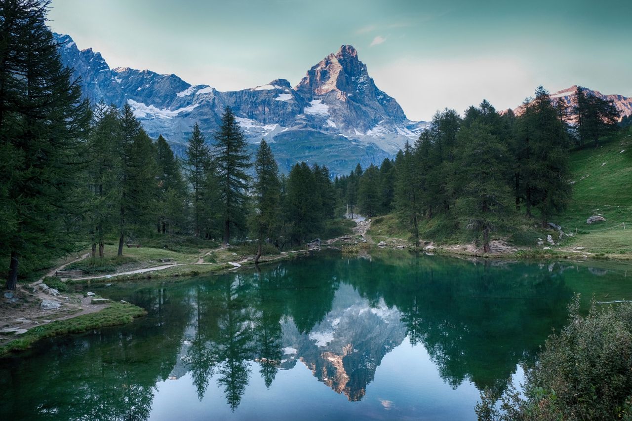 Serene view of mountains reflected in a lake at Breuil-Cervinia, Italy, showcasing nature's tranquility.